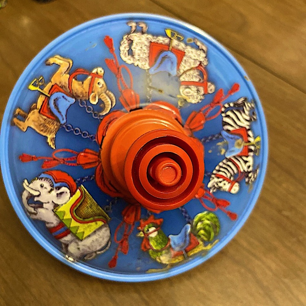 Vintage SMG Metal Spin Toy Top With Animal Cartoon Graphics In Red And Blue.